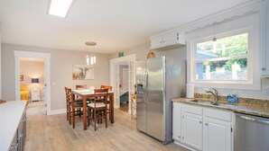 A modern kitchen with white cabinets, a stainless steel refrigerator, and a granite countertop. - Ivywood Escape Relaxing Stay (30+ Day Rental) (Nashville)