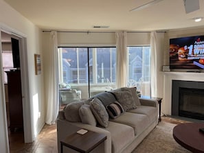 A living room with a sofa, a television, and a fireplace.
