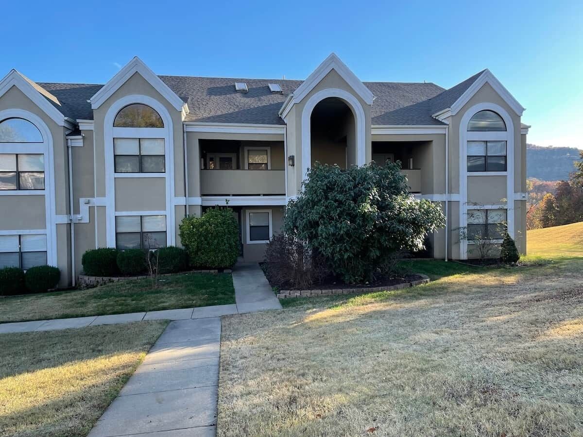 A two-story house with a front entrance, a covered porch, and a well-maintained lawn.