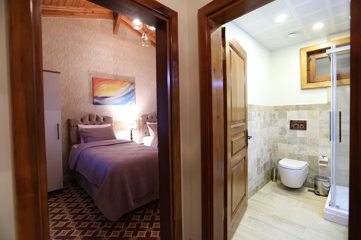Un dormitorio con cama, mesita de noche y un cuadro en la pared.