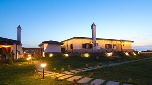 A well-lit building with two towers, a paved pathway, and a grassy area. - Tarihi Kumbaba Otel (Sile)