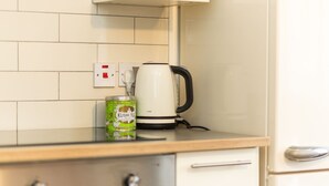 A kitchen with a coffee maker, a can of Kusmi Tea, and a power outlet. - Stylish 1BR Next to Tower Bridge (London)