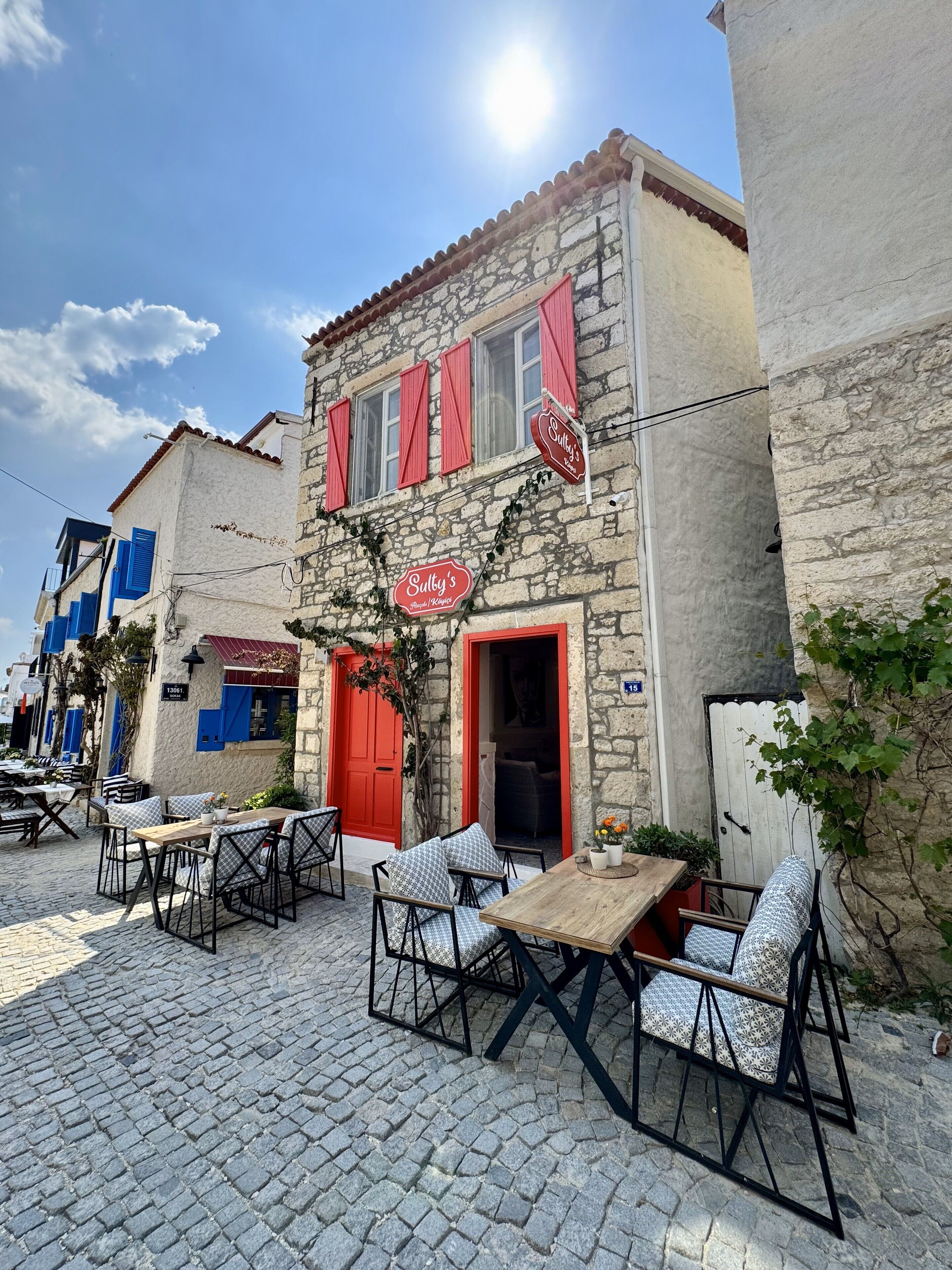 Un edificio de piedra con una puerta roja y un letrero que dice "Sulby's".