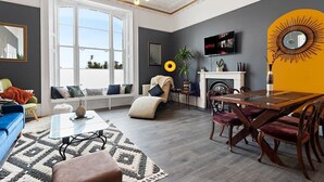 Un salon moderne avec un canapé, une table basse et un coin repas avec des chaises.