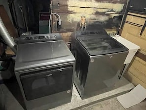 Utility room with two front-loading washing machines and a small storage cabinet.