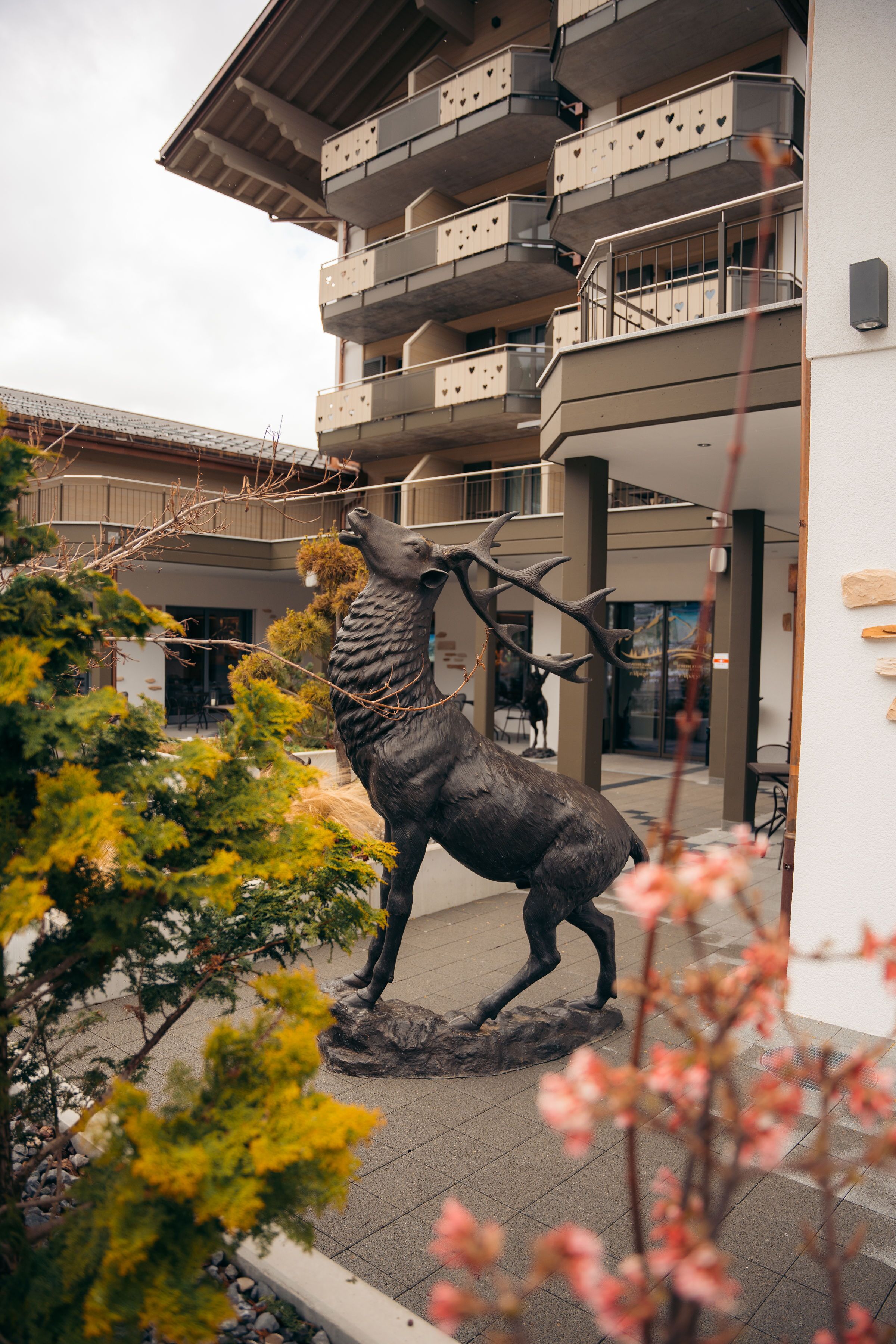 Un edificio con balcón y una estatua de un ciervo.