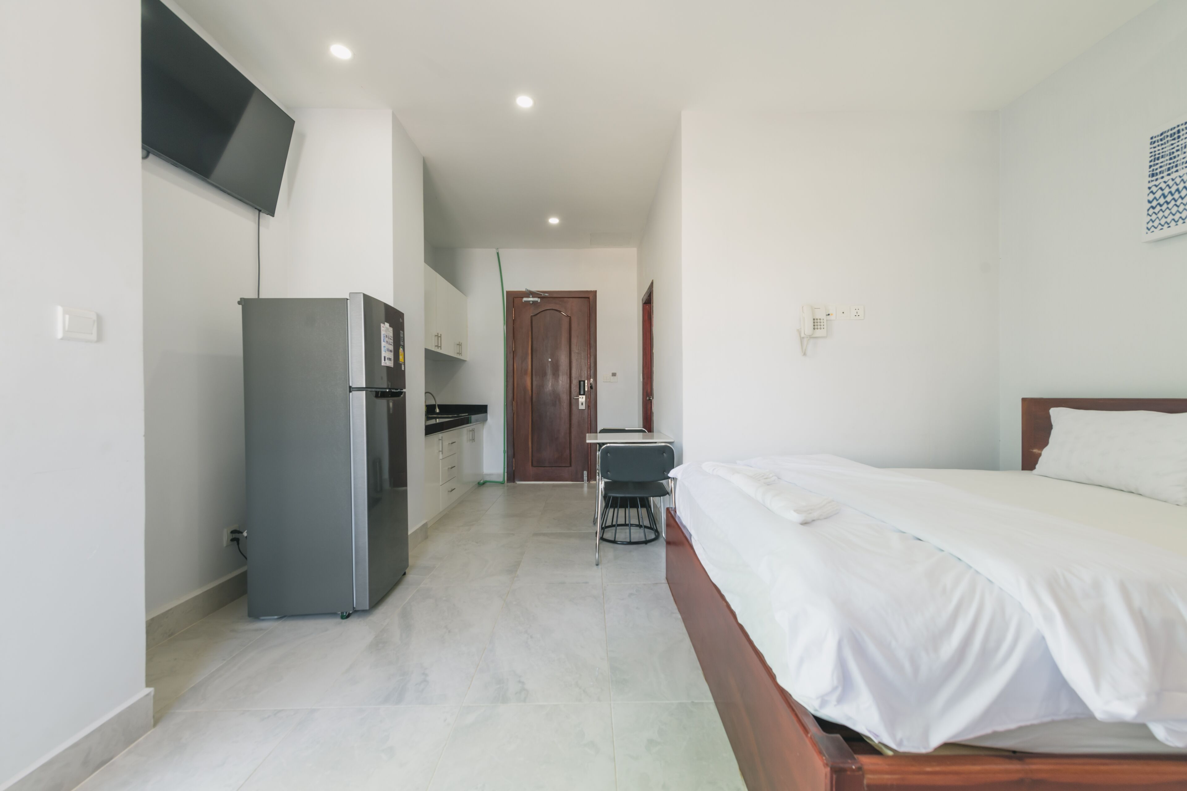 Une chambre à coucher avec un lit, un bureau et un réfrigérateur.