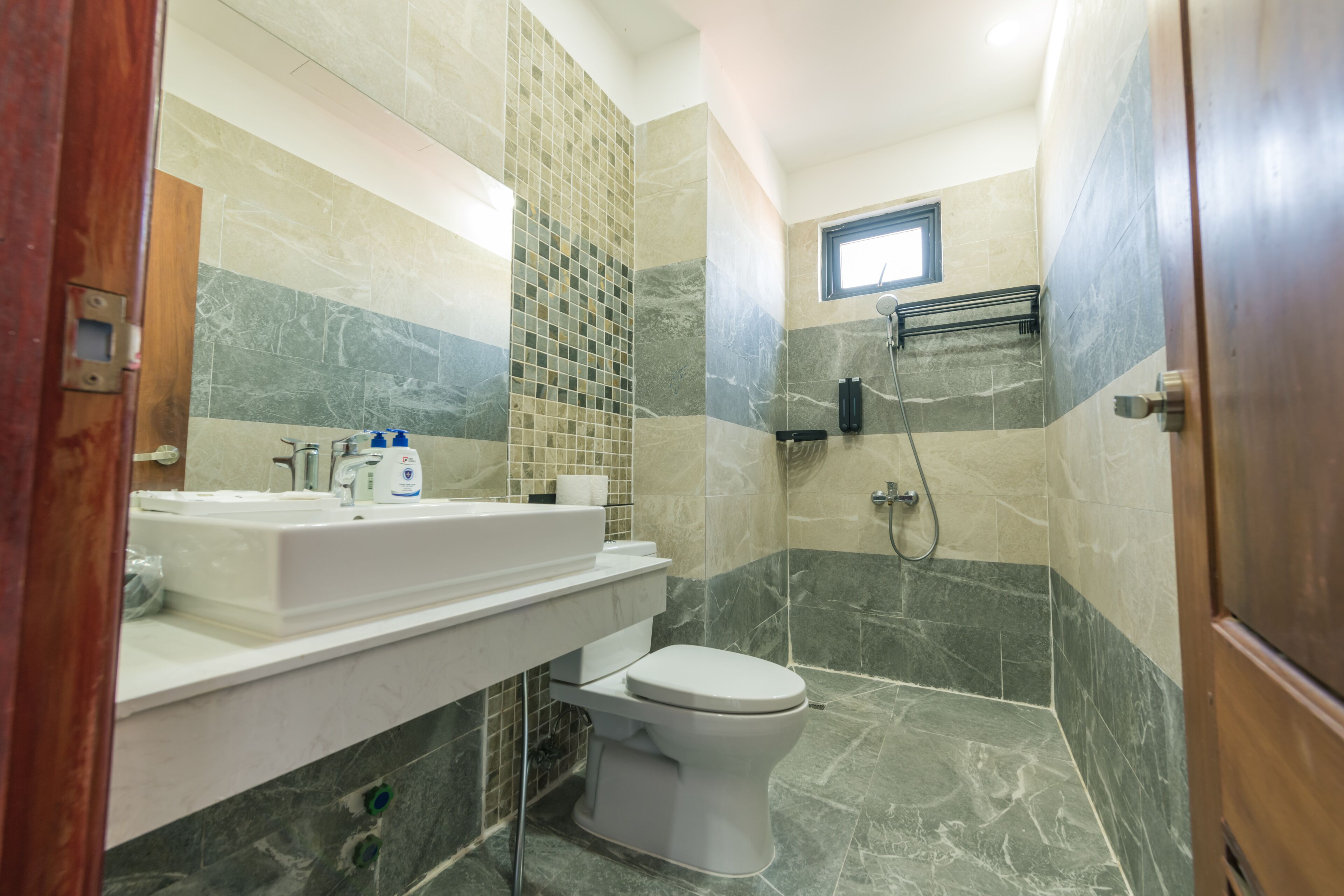 A bathroom with a white sink, a toilet, and a shower area.