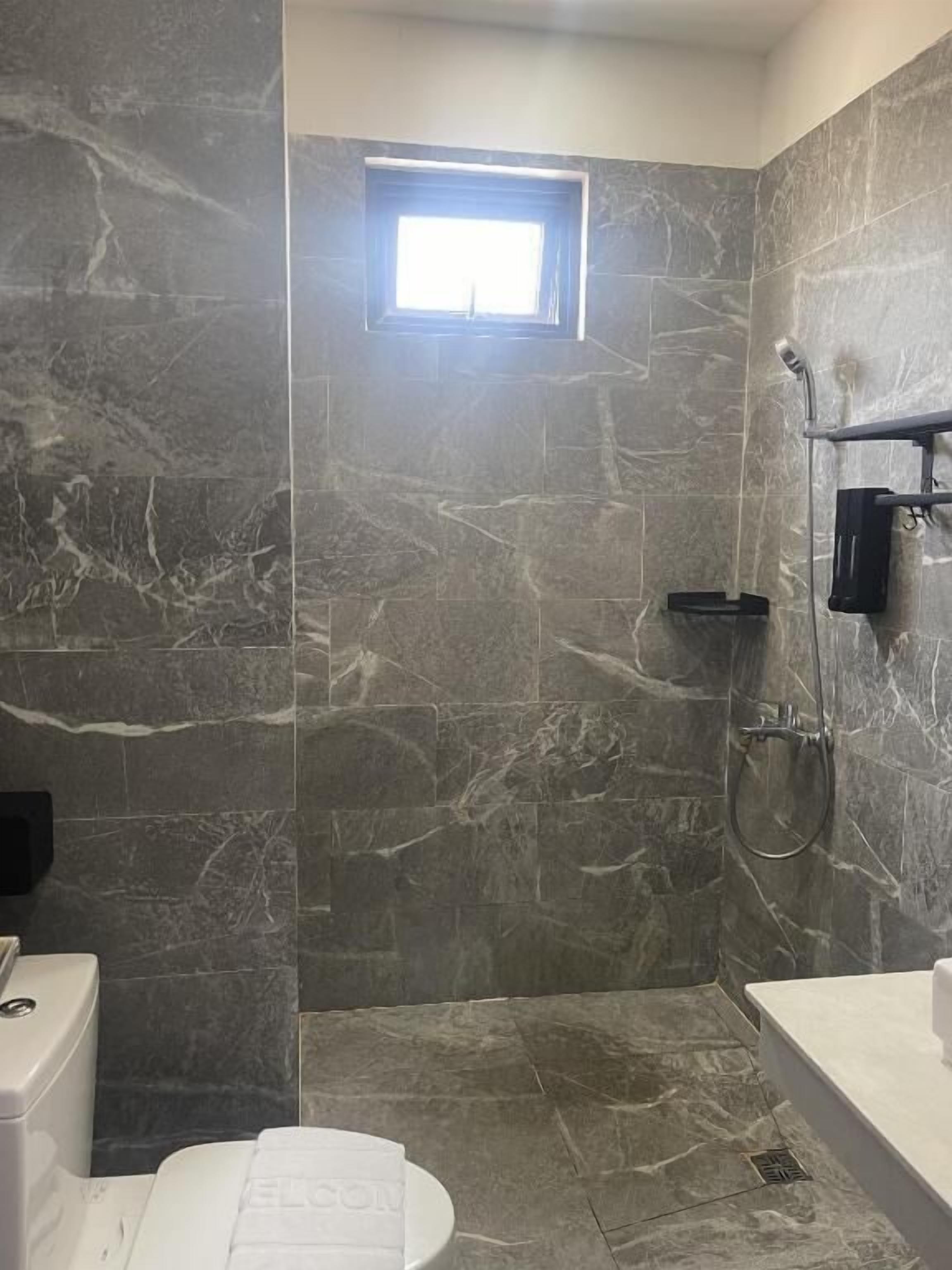 Ein Badezimmer mit Dusche, Toilette und Waschbecken.