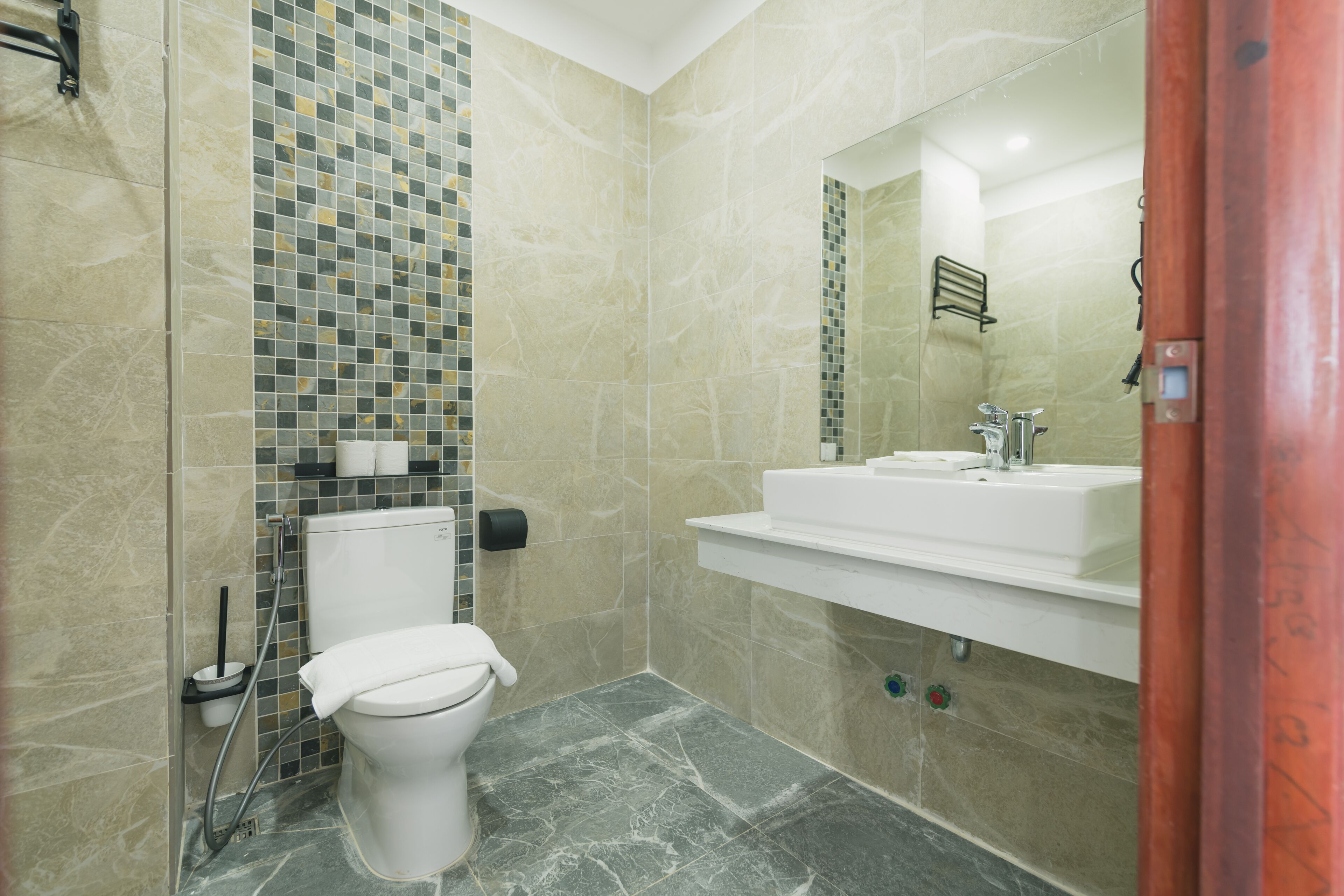Un baño con inodoro, lavamanos y zona de ducha.