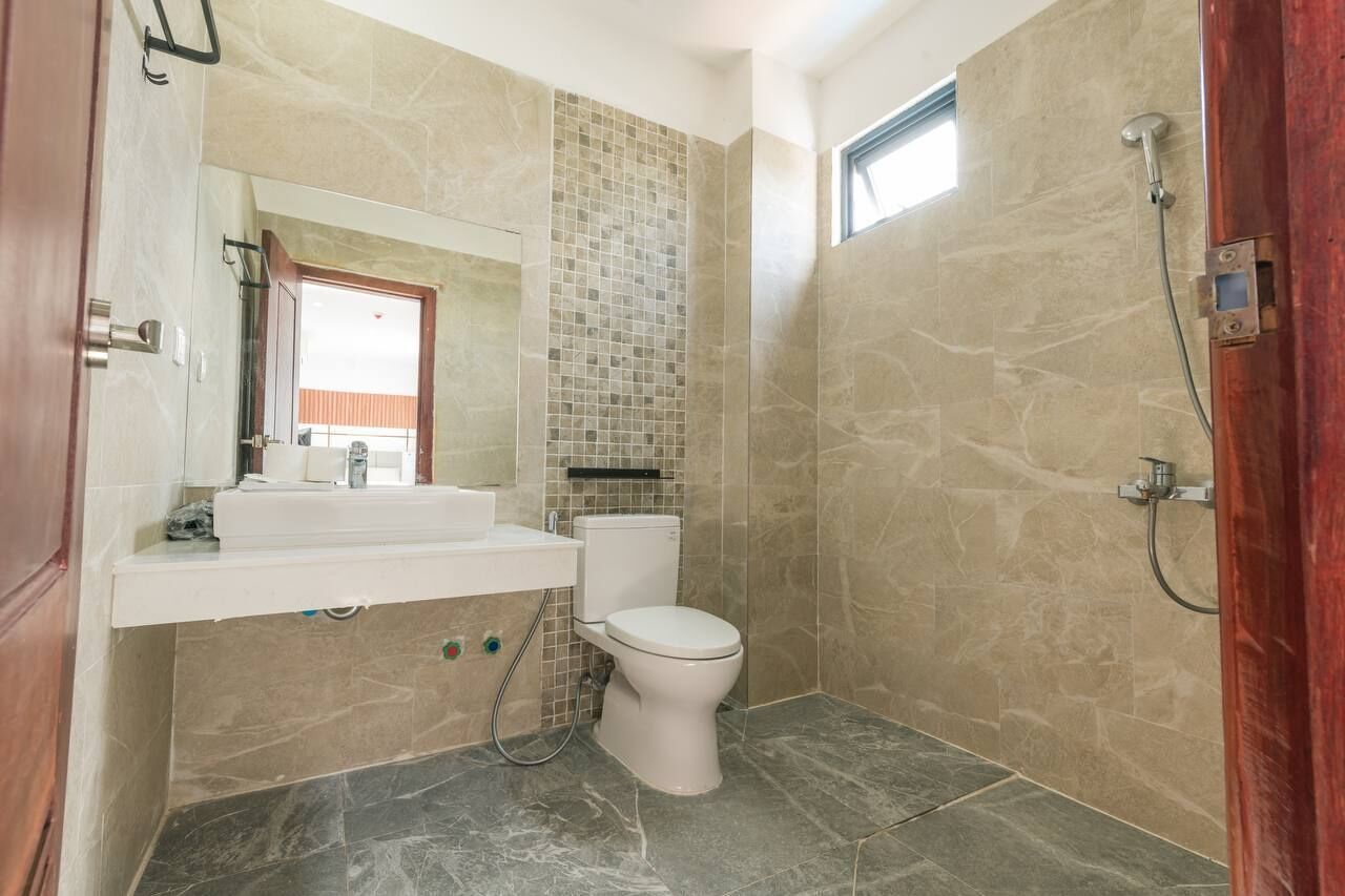 Une salle de bain avec des toilettes, un lavabo et une douche.