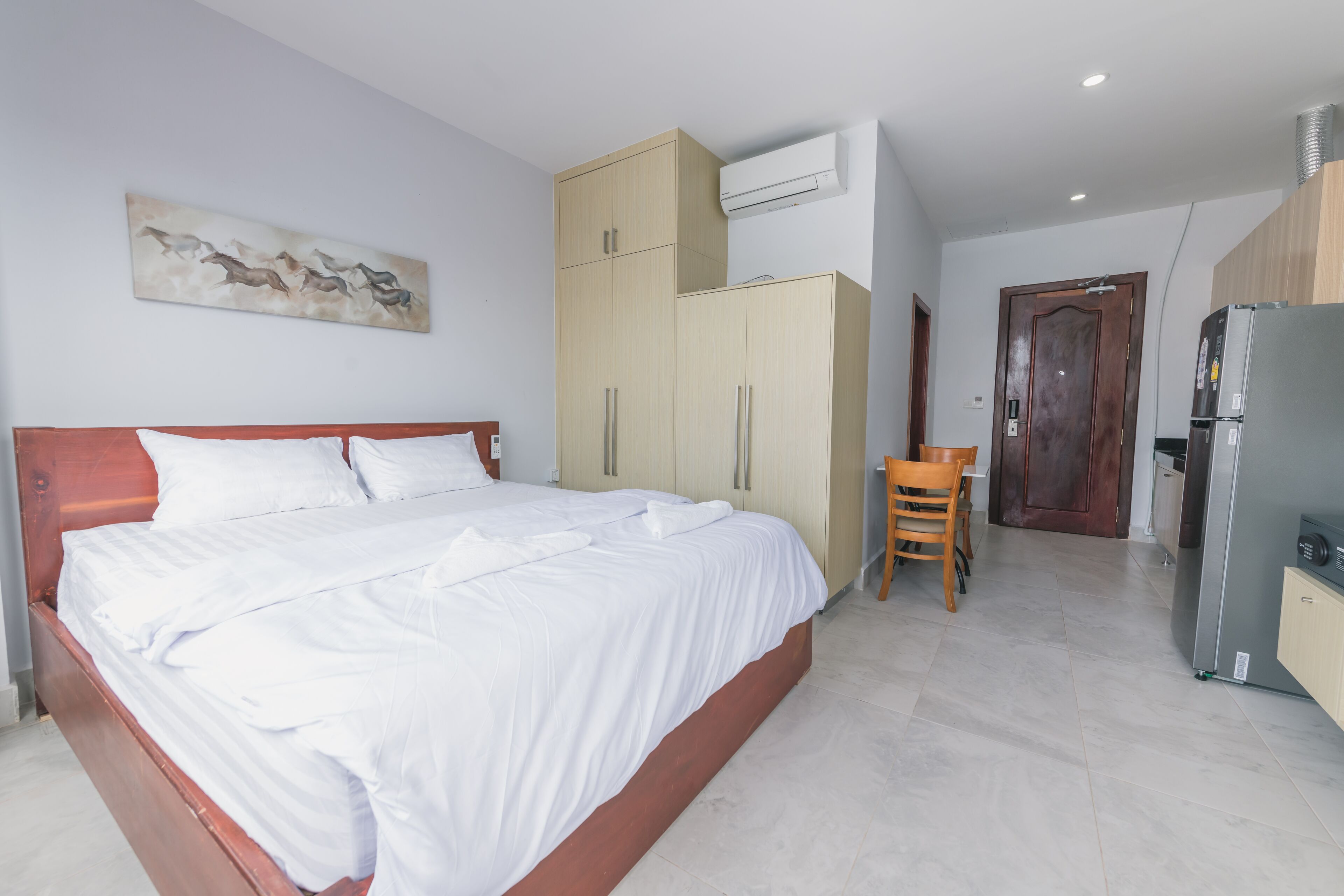 A bedroom with a bed, wardrobe, and a small table.