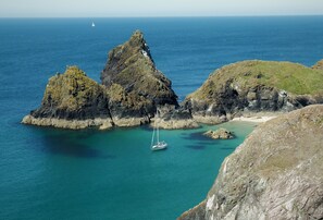 A coastal landscape with rocky formations and a clear blue sea.