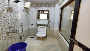 Baño pequeño y funcional con inodoro, ducha y ventana.