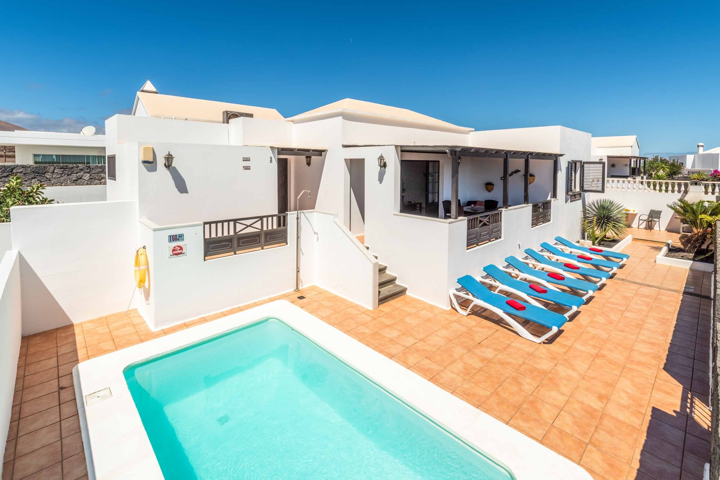 Een verwarmd zwembad en ligstoelen