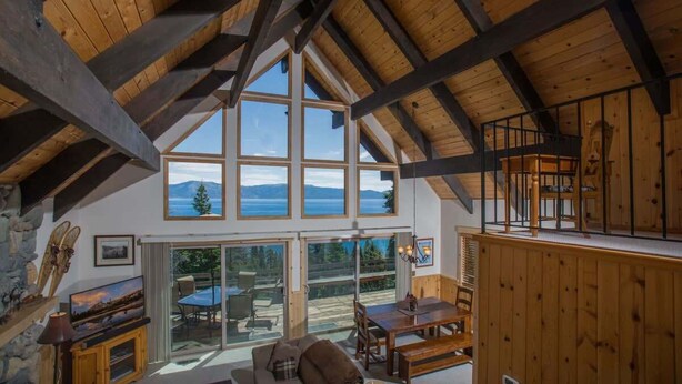 Um amplo quarto estilo loft, com pé direito alto, grandes janelas e vista para o exterior.