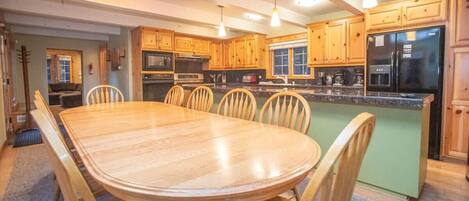 A spacious kitchen with wooden cabinets, a large island, and modern appliances.