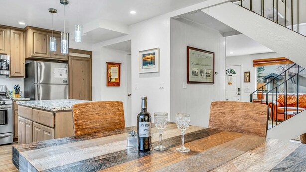 Una cocina moderna con armarios de madera, electrodomésticos de acero inoxidable y una isla grande con encimera rústica.