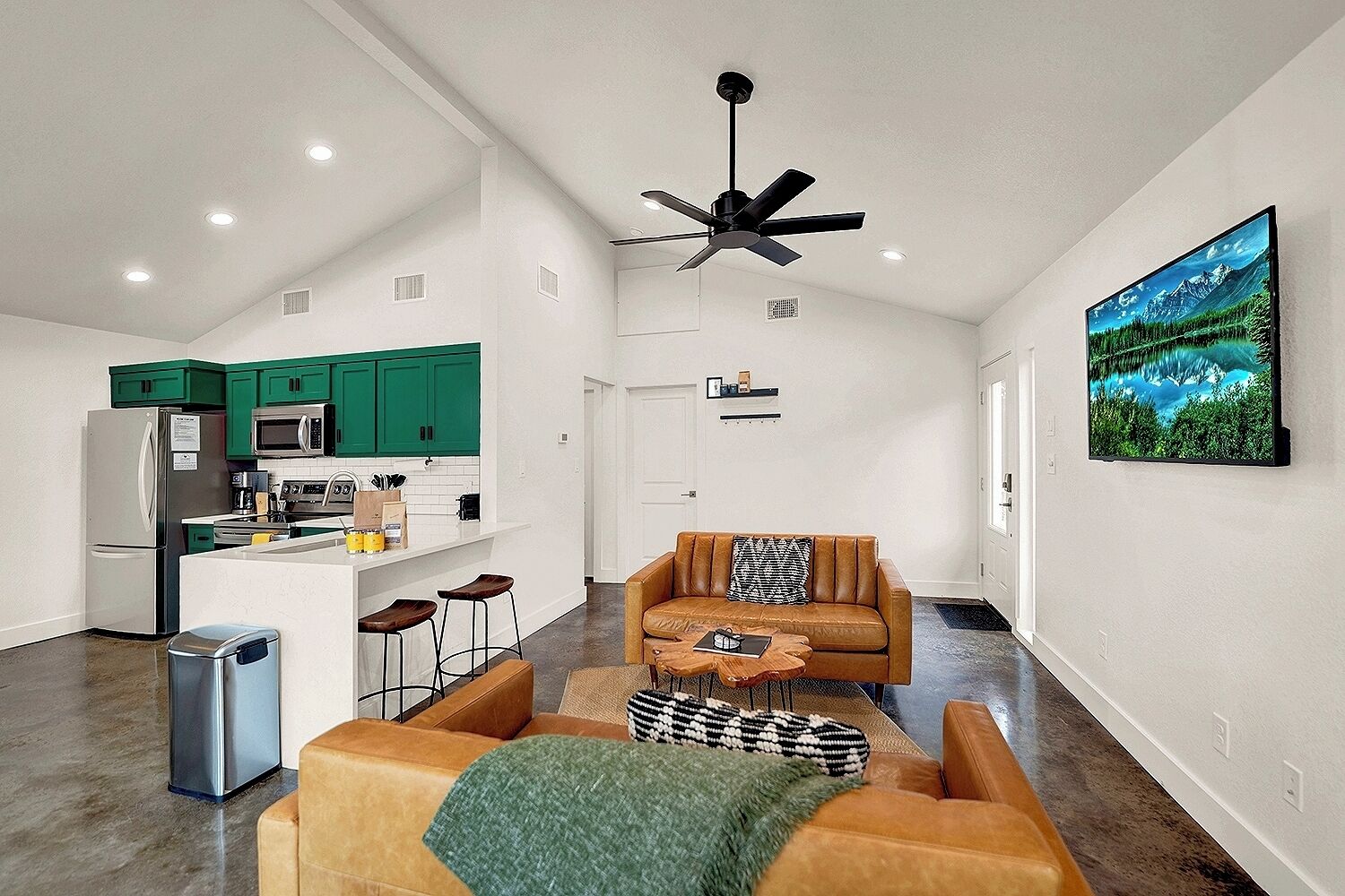 Un appartement moderne doté d’une cuisine, d’un espace de vie et d’une grande fenêtre.