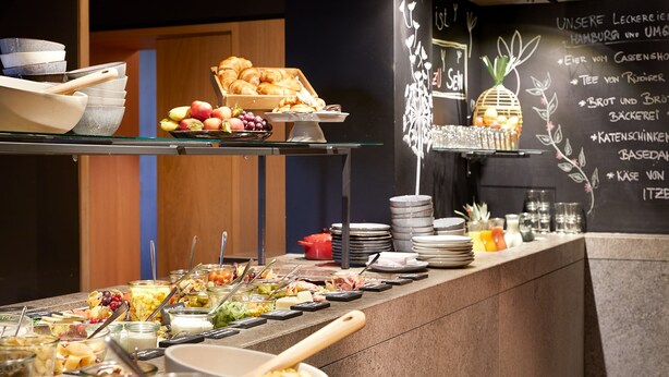 A buffet with various food items and utensils. - Wedina Serviced Apartments (Hamburg)