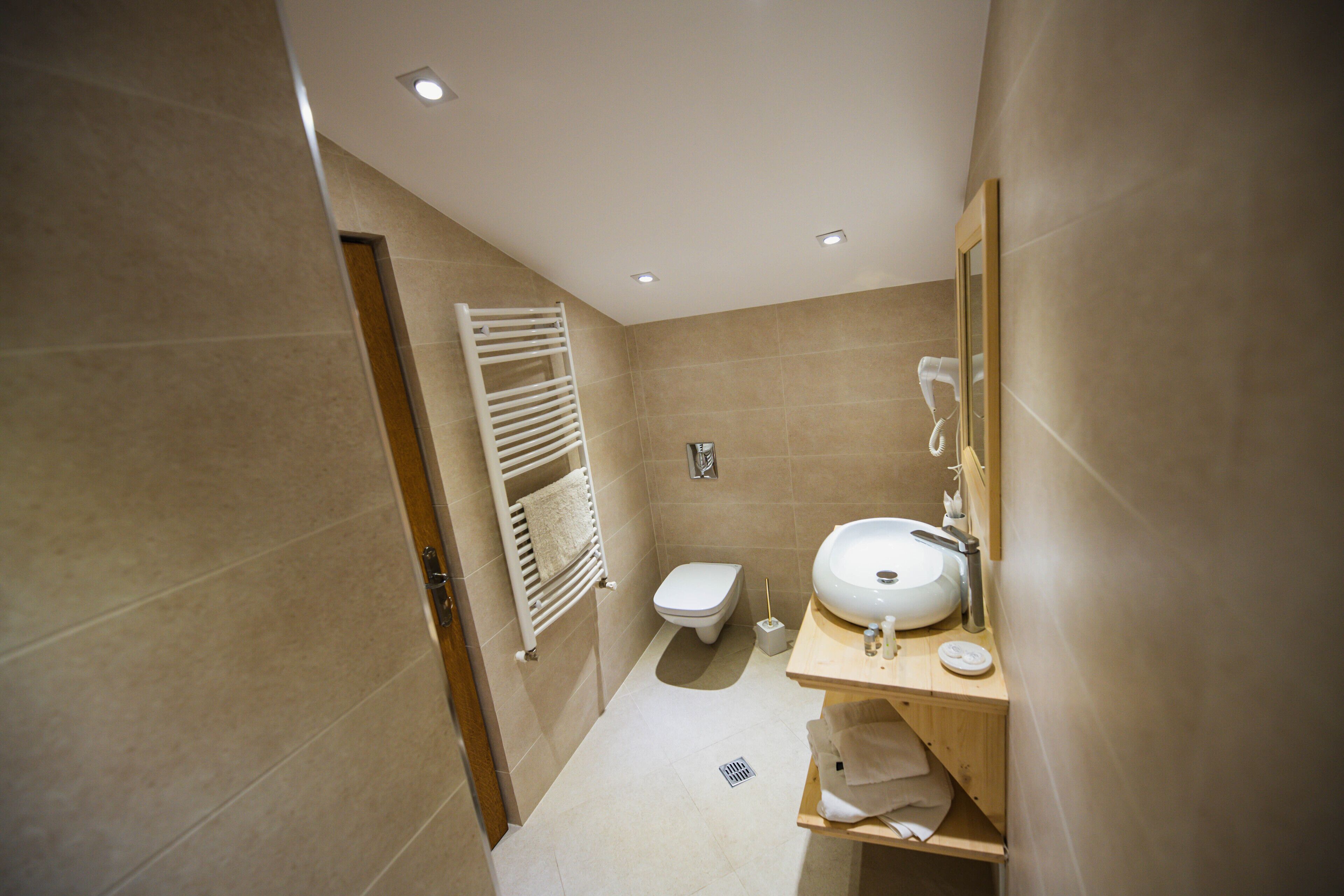 A small, modern bathroom with a toilet, sink, and towel rack.