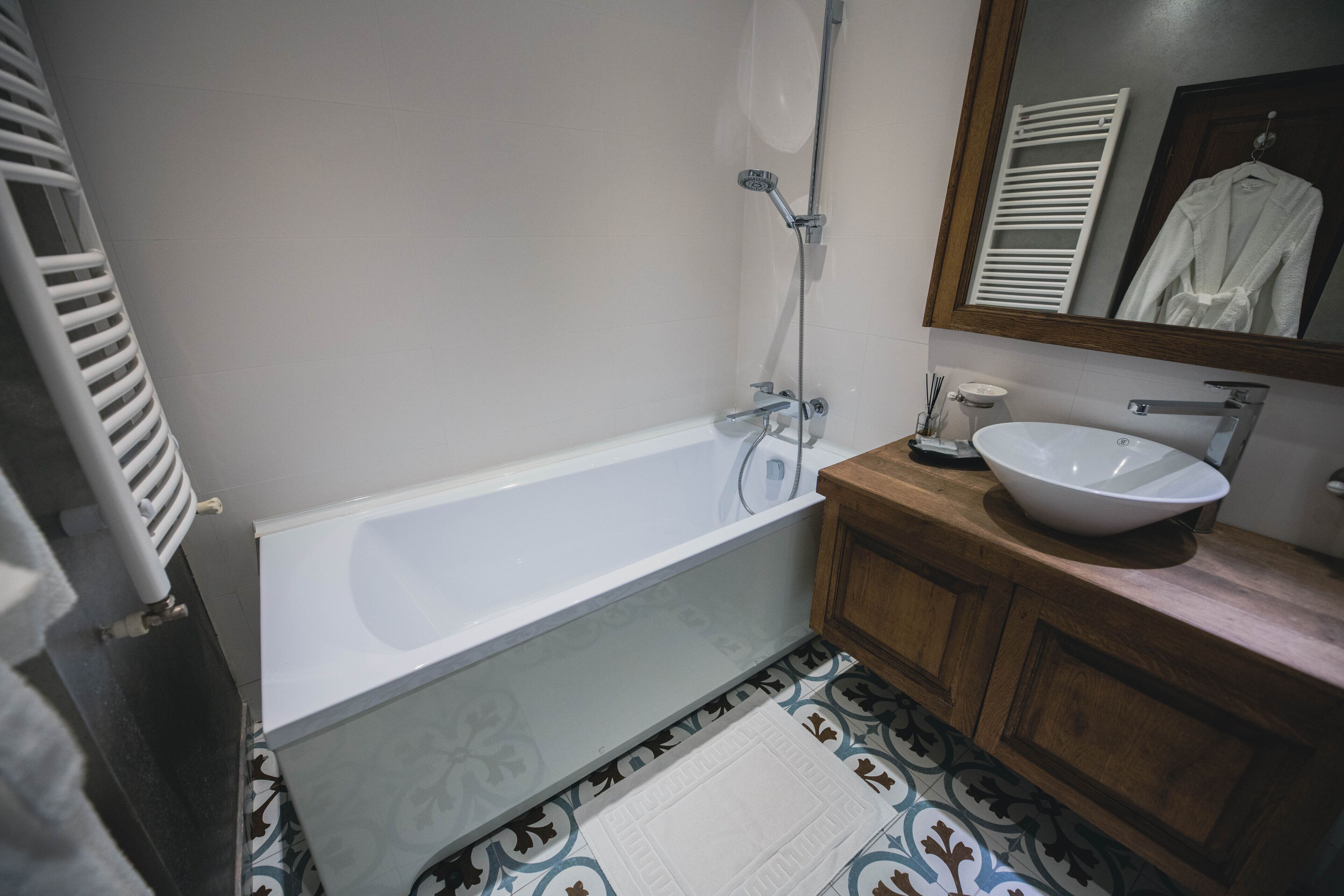 A bathroom with a bathtub, a sink, and a mirror.