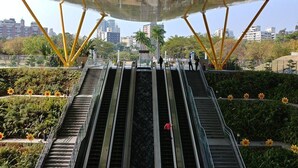 Un escalier mécanique extérieur doté d’une structure de toit en métal et de supports jaunes.