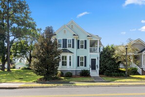 A two-story house with a front porch, a garage, and a well-maintained lawn.
