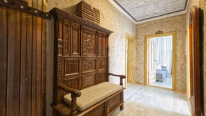 A room with a wooden bench, a mirror, and a door leading to another room. - Vacation apartment Herrenzimmer with fireplace and terrace (Annaberg-Buchholz)