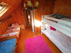 A cozy room with a bunk bed, a small desk, and a window. - House with large plot and mountain views (Le Noyer)