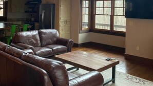 A spacious living room with a high ceiling, a large window, and a wooden ceiling fan. - Parade of Homes Cabin w/hot tub, outdoor fireplace, community riverfront!  (Blue Ridge)