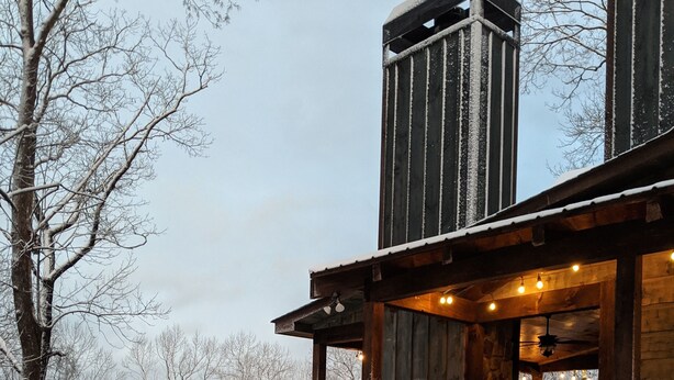 A wooden cabin with a balcony overlooking a snowy forest. - Parade of Homes Cabin w/hot tub, outdoor fireplace, community riverfront!  (Blue Ridge)