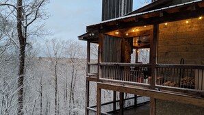 A wooden cabin with a balcony overlooking a snowy forest. - Parade of Homes Cabin w/hot tub, outdoor fireplace, community riverfront!  (Blue Ridge)
