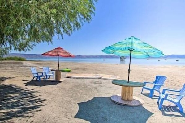 Relax on the beach with comfortable seating under shaded umbrellas.
