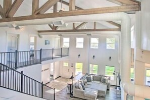 Spacious interior with a central seating area and staircase leading to multiple levels.