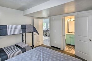 Cozy accommodations feature a bunk bed and single bed, a bathroom with a sink and cabinet.