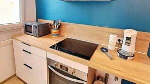 Una cocina moderna con horno empotrado, microondas y campana extractora de acero inoxidable.