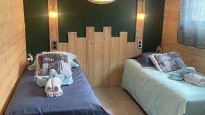 Une chambre avec deux lits, des murs en bois et un élément décoratif mural.