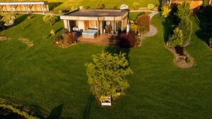 Une maison moderne dotée d’un patio couvert, d’un jacuzzi et d’une pelouse parfaitement entretenue.