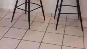 Un área de cocina con dos taburetes de bar, una encimera y alacenas.