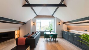 En moderne loftlejlighed med køkken, spiseområde og siddeplads.