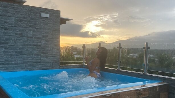 Un jacuzzi con vista a un paisaje montañoso al atardecer.