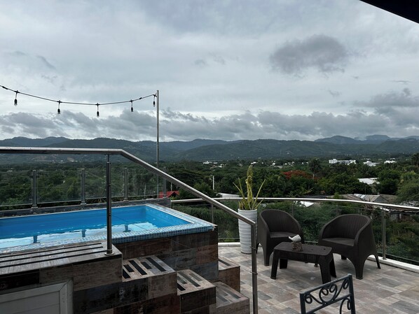 A rooftop pool area with a view of mountains, a staircase, and outdoor furniture. - Apartment with jacuzzi (Santiago De Los Caballeros)