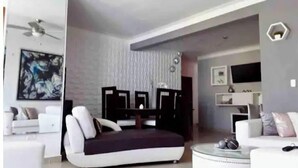 Een moderne woonkamer met een bank, een salontafel en een televisie.