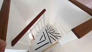 A staircase with wooden handrails and white walls.