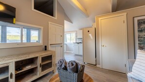 A modern kitchen with white cabinets, a built-in oven, and a window overlooking a garden. - Delightful Lake View Cabin in Alton Bay Now featuring Lake Access, AC/ TV/ WiFi (Alton)