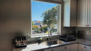 A kitchen with a window, a toaster, a sink, and cabinets. - Flat at the Cork Oak · Sunny, central, quiet flat + yard (Petaluma)