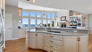 A kitchen with a large island, a view of the ocean, and a fireplace. - Carpe Beachiem Home, Ocean Views & Dual Decks (Ponte Vedra Beach)