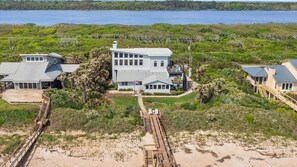 A large beachfront property with multiple buildings, including a main house with a large deck and a smaller structure. - Carpe Beachiem Home, Ocean Views & Dual Decks (Ponte Vedra Beach)