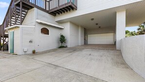 A two-story house with a covered driveway, a garage, and a small outdoor area with a potted plant. - Carpe Beachiem Home, Ocean Views & Dual Decks (Ponte Vedra Beach)